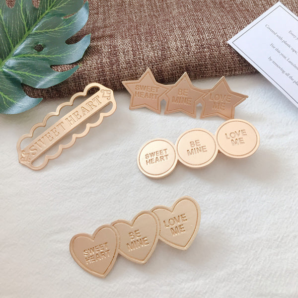 Gold alloy letter clip hair accessories with engraved messages like 'BE MINE' and 'LOVE ME', ideal for weddings and travel gifts in Europe.