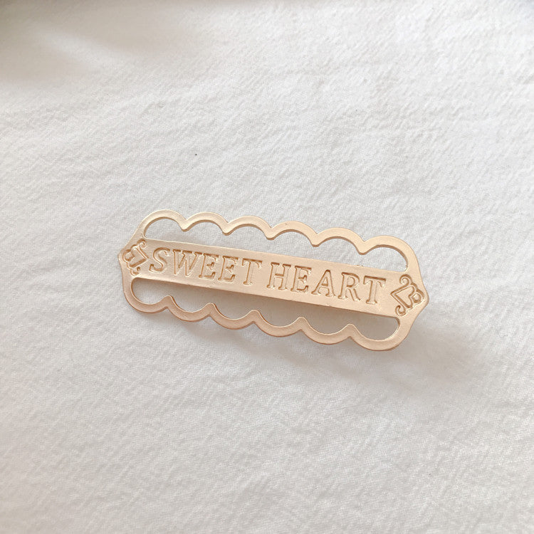 Gold alloy letter clip hair accessory with engraved messages 'SWEET HEART', 'BE MINE', and 'LOVE ME', ideal for weddings or travel gifts in Europe.