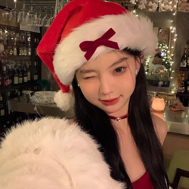 Ladies Christmas Bow Hathat headwear for bank robbers crossword featuring a black tall crown Santa hat with white faux fur trim and a red outfit.