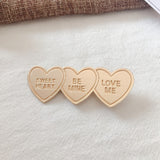 Gold alloy letter clip hair accessory with engraved messages 'SWEET HEART', 'BE MINE', and 'LOVE ME', ideal for weddings or travel gifts in Europe.