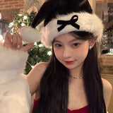 Ladies Christmas Bow Hathat headwear for bank robbers crossword featuring a black tall crown Santa hat with white faux fur trim and a red outfit.