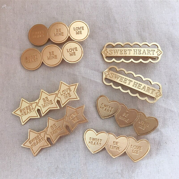 Gold alloy letter clip hair accessories with engraved messages like 'BE MINE' and 'LOVE ME', ideal for weddings and travel gifts in Europe.